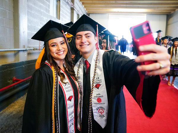 two student taking photos at graduation