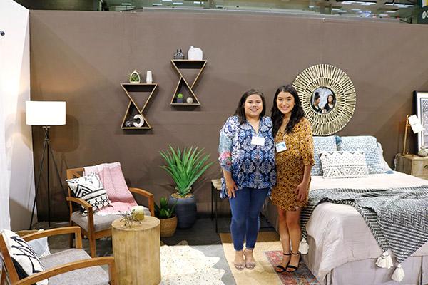 Students standing amid their interior design showcase during the Home and Garden show