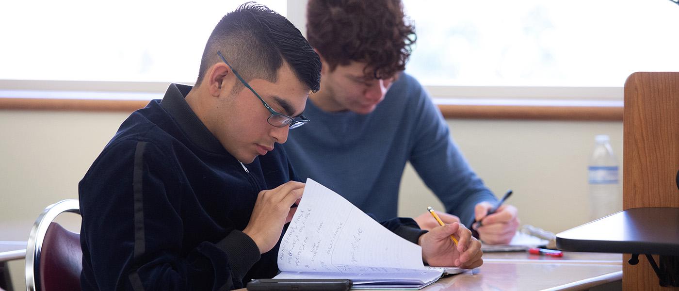两名男学生在数学课上做笔记的特写